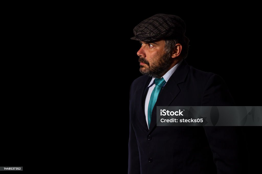 Businessman looking aside wearing a suit and a flat cap Businessman looking aside wearing a suit and a flat cap. 40-49 Years Stock Photo