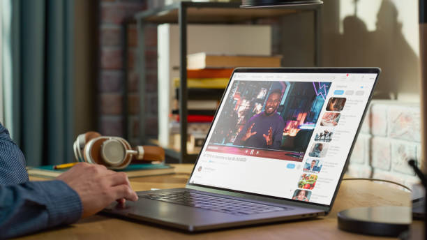 Close Up on Male Hands Using Laptop to Watch Video Sharing Service Mock-up Where African American Influencer Talks About Lifestyle. Interface with Related Streams, Likes, Comments. de cerca las manos masculinas usando una computadora portátil para ver la maqueta del servicio para compartir videos donde un influencer afroamericano habla sobre el estilo de vida. interfaz con flujos relacionados, me gusta, comentarios.