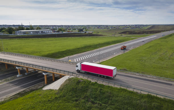 istock Truck with Cargo Semi Trailer Moving on Road in Direction. Highway intersection junction. Aerial Top View 1448542565