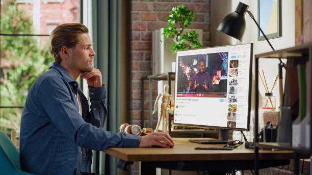 istock Handsome Man Watching Video Sharing Service Mock-up Where African American Influencer Talks About Lifestyle. Celebrity Blogger Having fun. Interface with Related Streams, Likes, Comments. 1448542655