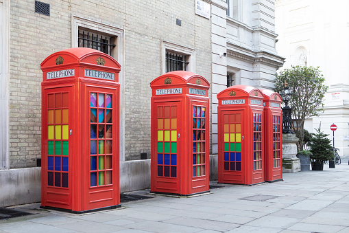 istock Row of red telephone boxes in LGBT rainbow colours 1448542823