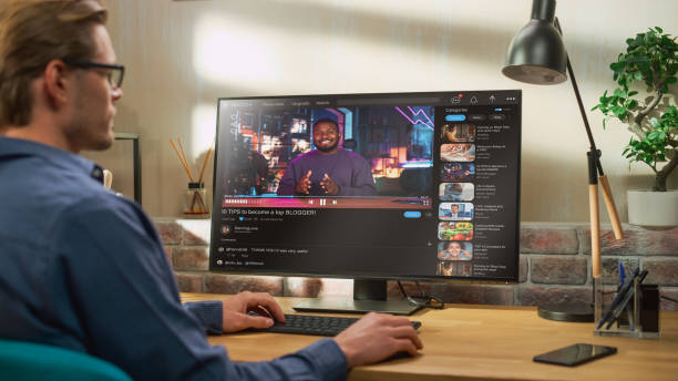 istock Handsome Man Watching Video Sharing Service Mock-up Where African American Influencer Talks About Lifestyle. Celebrity Blogger Having fun. Interface with Related Streams, Likes, Comments. 1448543619