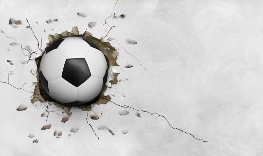 Soccer ball flying through the wall with cracks