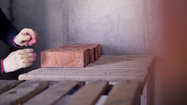 a worker at a construction site shifts bricks