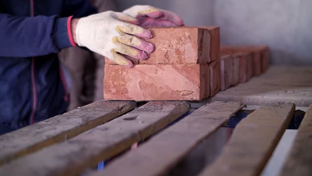 a worker at a construction site shifts bricks