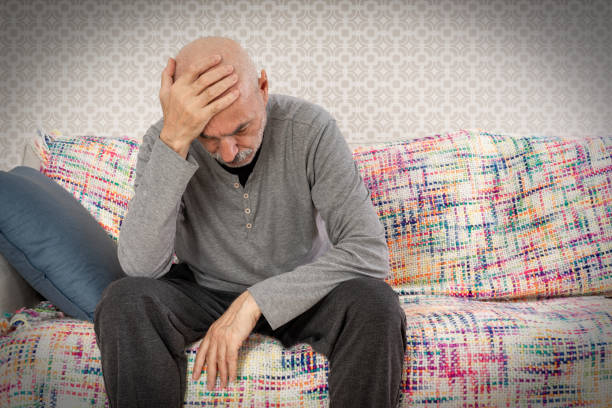 istock Sad and Thoughtful Old Man Sitting on Sofa 1448546619