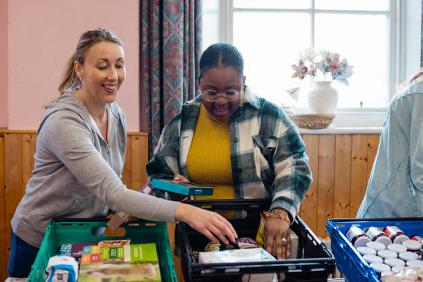 Community making Donations Food bank being run by volunteers at a community church in the North East of England. People in need are collecting groceries/toiletries there. community center food stock pictures, royalty-free photos & images