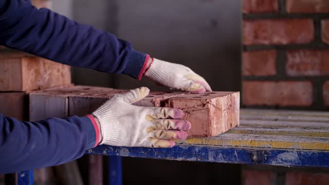 a worker at a construction site shifts bricks