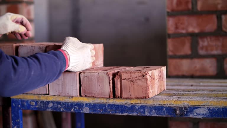 a worker at a construction site shifts bricks