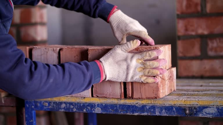 a worker at a construction site shifts bricks