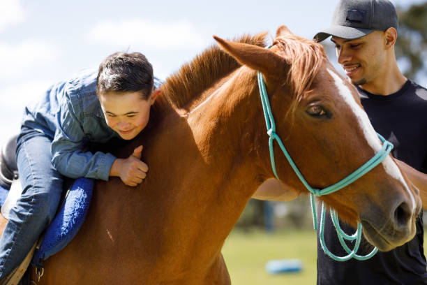 istock Down syndrome boy sitting on a horse back and hugging it's neck 1448548109