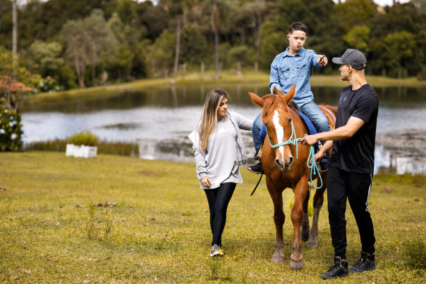 istock Young boy riding a horse with caretakers help 1448548218