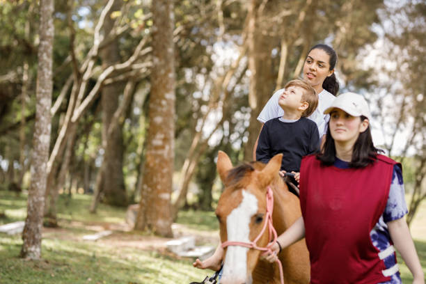 istock Curious little boy looking around while on a horse ride with caretakers 1448548237