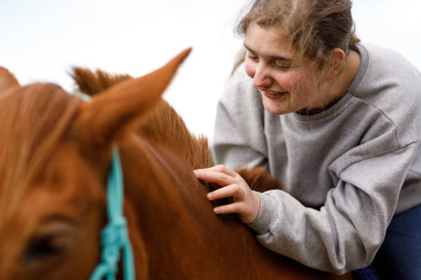 istock Smiling girl on a horse back caressing it's neck 1448548288
