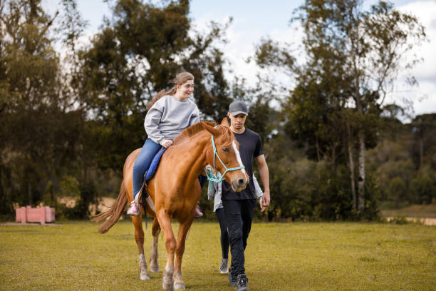 istock Happy girl with special needs riding a horse during therapy 1448548806