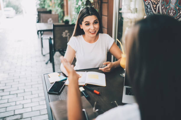 istock Cheerful women discussing business at pavement cafe 1448549741