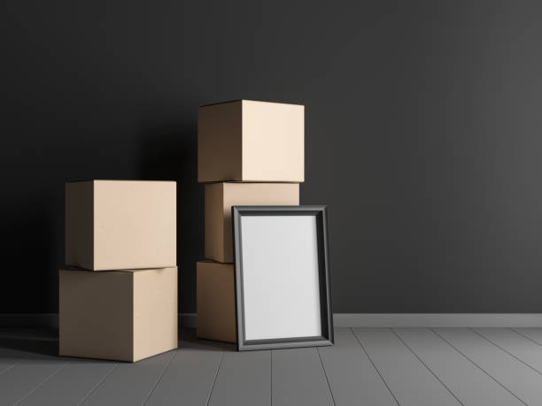 istock Vertical Black Wooden Frame Mockup standing near large cardboard boxes in empty interior with dark wall 1448551275