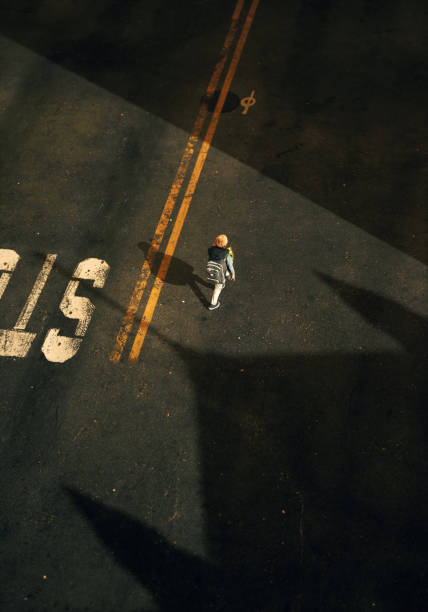 Lone boy with backpack walks on a street. High angle view. 3D render.