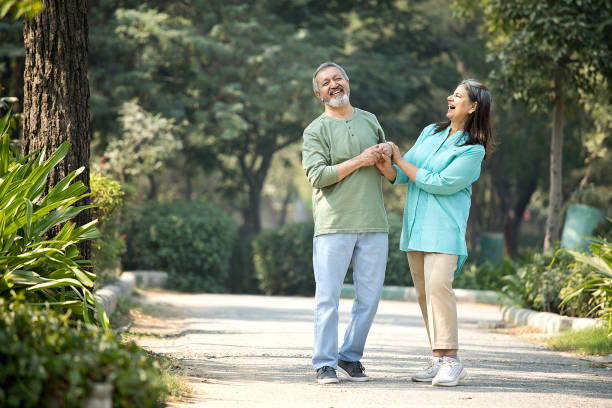 istock Cheerful senior couple holding hands while standing in park 1448553561
