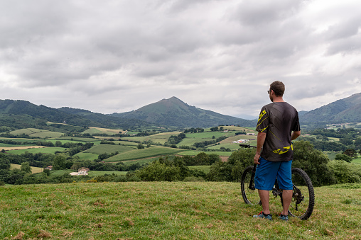 Man with a mountain bike standing and looking at the beautiful landscape.