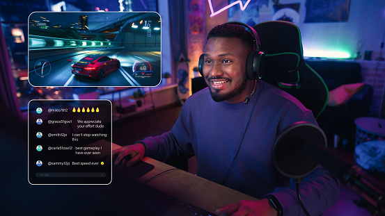 Excited African American Streamer Playing a Racing Video Game. Man Streaming His Gaming Progress from Home in Living Room Apartment. Followers Engaging Through Interface, Live Broadcast on Internet.