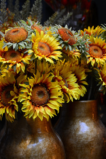 Two artificial sunflower bouquets standing in a Vase.