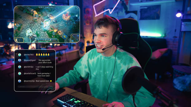 istock Excited Streamer Playing a Video Game Online. Stylish Man Streaming His Gaming Progress from Home in Living Room Apartment. Followers Engaging Through Interface During Live Broadcast on Internet. 1448556538