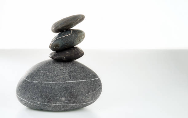 istock A pyramid of four stones in balance on a white background. 1448557732