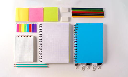 Mockup. An empty school notebook,pencil, erasers,stickers on a white background, top view,flat lay