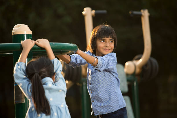istock Siblings playing on exercise machine in playground at sunset 1448559615