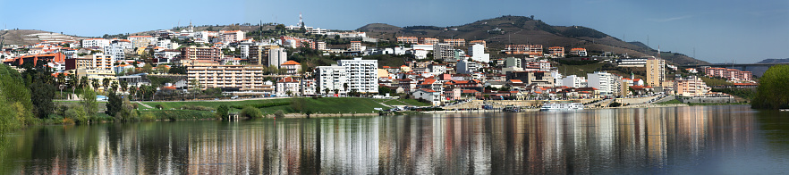 Peso da Régua townscape reflected on Douro River, Portugal . Vila Real district.  Panoramic view.
