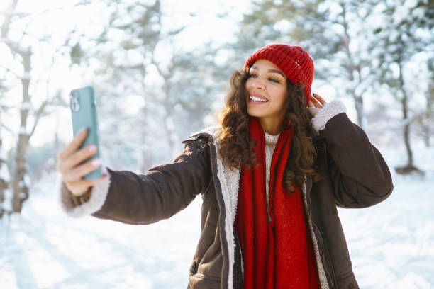 istock Happy woman taking selfie in winter forest. 1448565895