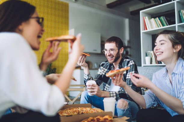 istock Laughing friends enjoying pizza during party 1448566089