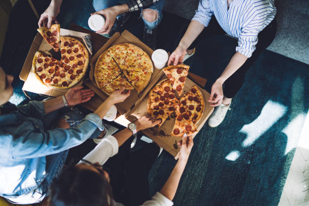 istock Unrecognizable friends eating pizza during party 1448566170