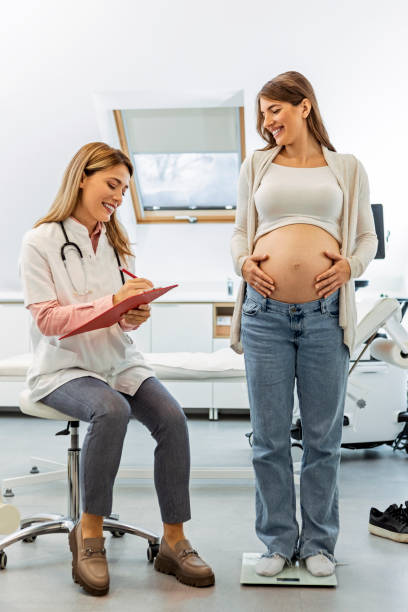 schwangere frau auf der gewichtswaage in arztpraxis - dieting weight scale doctor patient stock-fotos und bilder