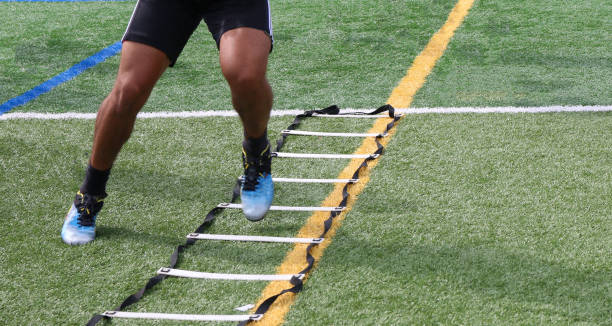 Legs of an athlete running side to side in a football ladder drill stock photo