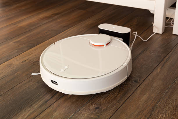 istock Robotic vacuum cleaner on laminate wood floor smart cleaning technology 1448569381