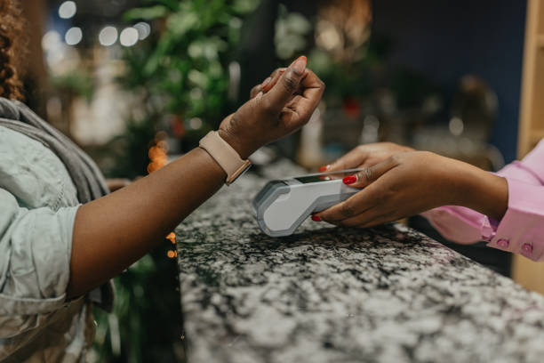 istock Young African American woman paying for goods using wireless payment 1448569710