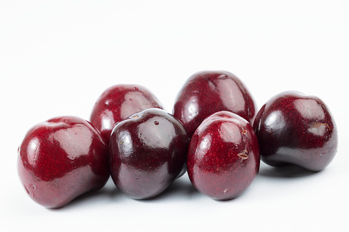 Red cranberries, a pile of fresh berry fruit that is an ingredient of traditional Thanksgiving meals. The stack of autumn food is cut out and isolated on white background, with soft shadows adding dimension. Bog harvested, the grocery may become juice, sauce, jam, or jelly in a healthy eating diet.