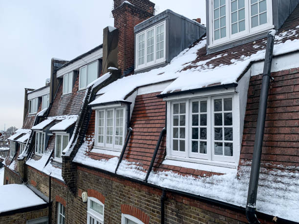 View of lookalike Parisian rooftops from Holy mount in Hampstead, Camden, North London, England, UK. Winter in London, Snow, snowing in London. Hampstead is an affluent residential community long favoured by academics, artists, and media figures. Hampstead Heath has meadows, woodland, and swimming ponds, plus city views from Parliament Hill. Open to the public, Kenwood House is a neoclassical villa with a collection of Old Master art. Boutiques, gastropubs, and upmarket restaurants occupy the Georgian buildings and alleyways of quaint Hampstead Village. winter wonderland london stock pictures, royalty-free photos & images