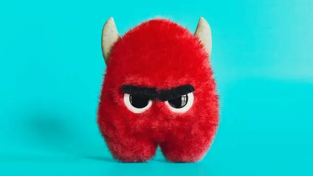 Fluffy red angry monster, devil with horns toy, funny looking furry mascot