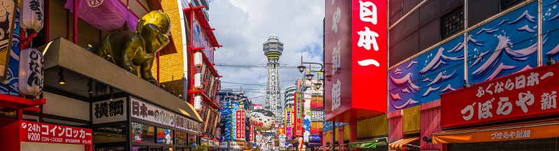 The iconic spire of the Tsutenkaku Tower overlooking the colourful bars and restaurants of Shinsekai in the heart of Osaka, Japan’s vibrant second city.