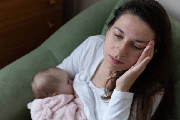 istock Mother experiences headache while breastfeeding her daughter. 1448579646