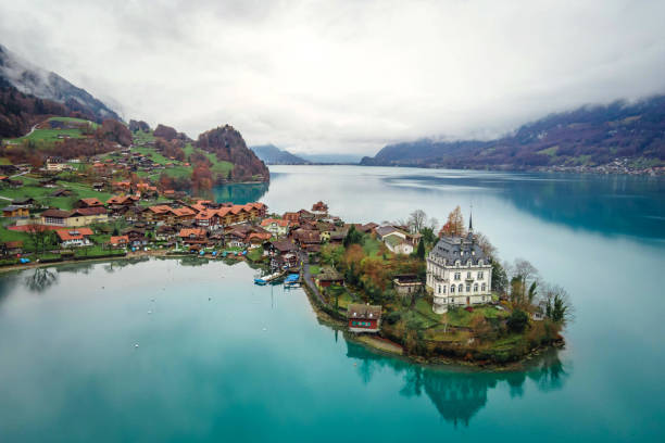 vista aerea, villaggio di iseltwald con idilliaco scenario naturale del lago di brienz con acque turchesi. svizzera - brienz house switzerland european alps foto e immagini stock