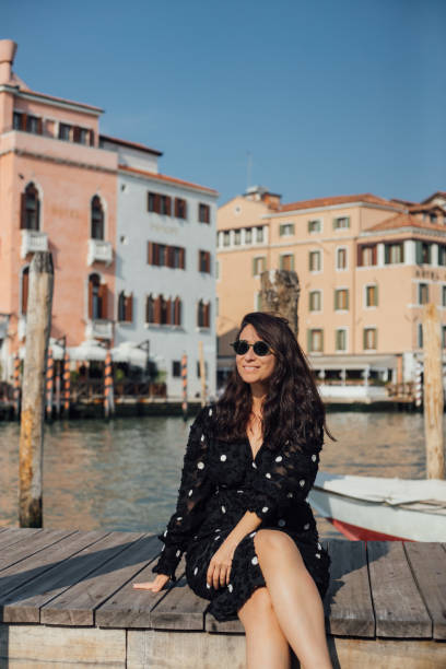 istock Woman posing the camera on dock in venice 1448580900