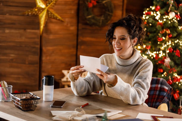 istock Young woman folding a Christmas letter that she wrote 1448582181