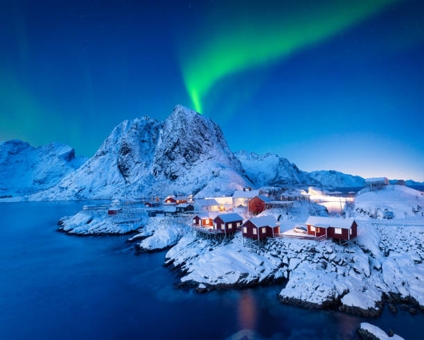 Aurora Borealis. Northern Lights. View on the house in the Hamnoy village, Lofoten Islands, Norway. Landscape in winter time. Mountains and water. stock photo