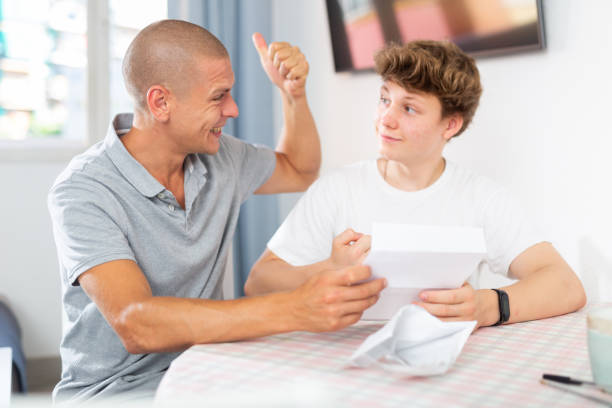 istock Joyful father and son cheering after reading letter from college 1448583859