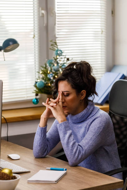 istock Worried young woman sitting at her desk, stressing out while working 1448584686