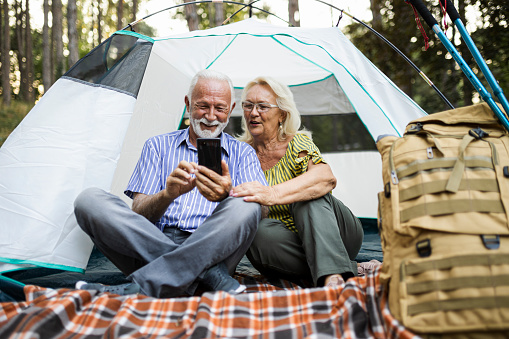 Senior Couple On Autumn Camping Trip having video call